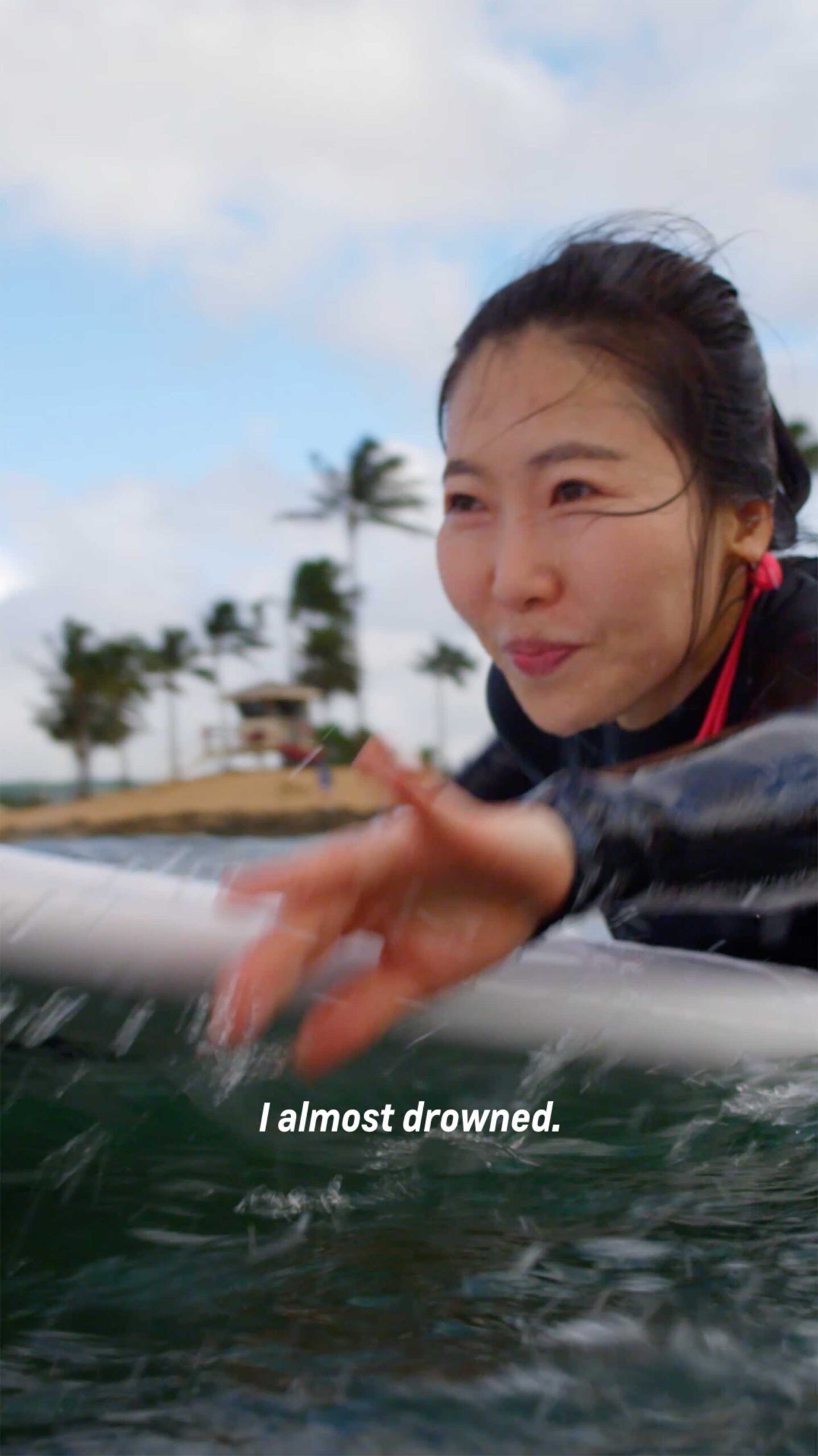 Mihwa, a young Korean woman, paddles on her board with confidence, about to catch a wave as part of the Chevrolet New Year New Roads campaign.