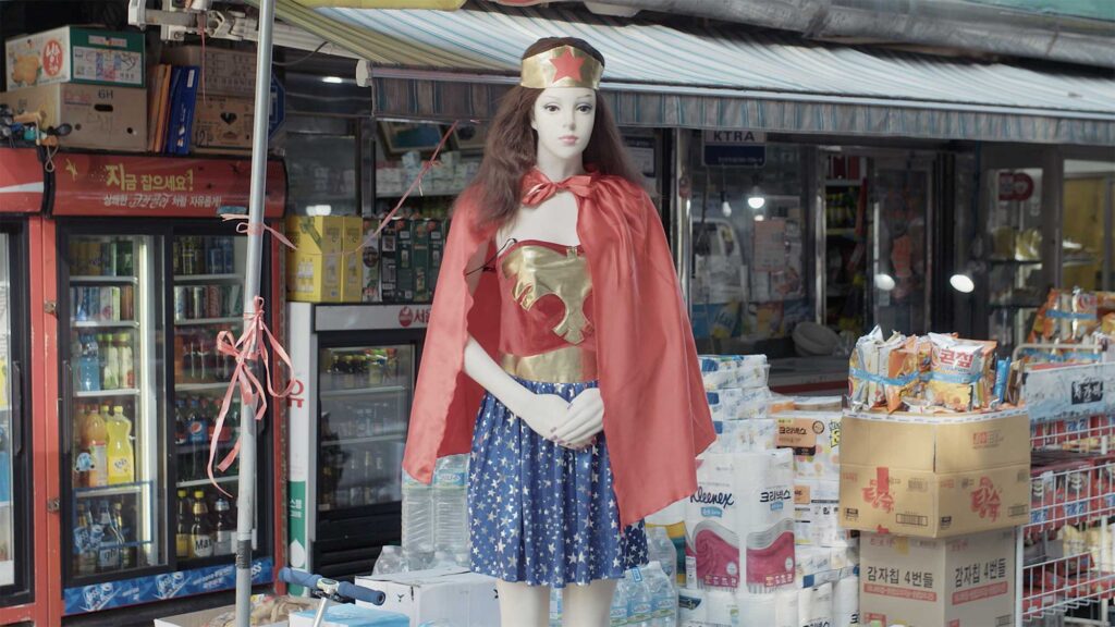 Plastic doll in short skirt shaped like human stands outside Korean supermarket in Seoul, South Korea.