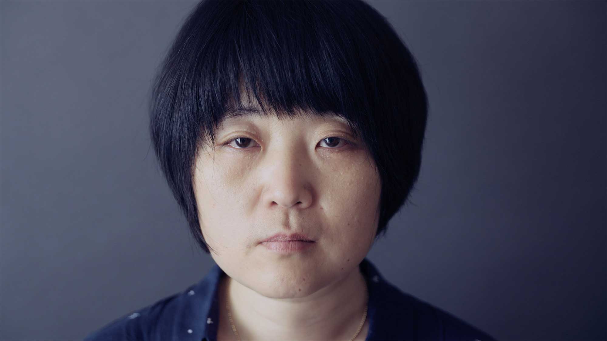 A close-up portrait of a mother, showing her deep grief over the loss of her daughter, who was among the many lives lost in the Sewol ferry disaster in South Korea.
