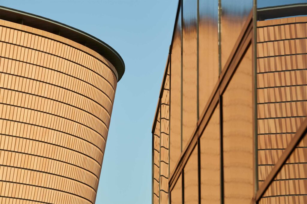 Close-up of the terra cotta brick complex by Mario Botta, part of Leeum, Samsung Museum of Art, reflecting in the glass facade of the Samsung Child Education & Culture Center, designed by Rem Koolhaas, in Seoul, South Korea.