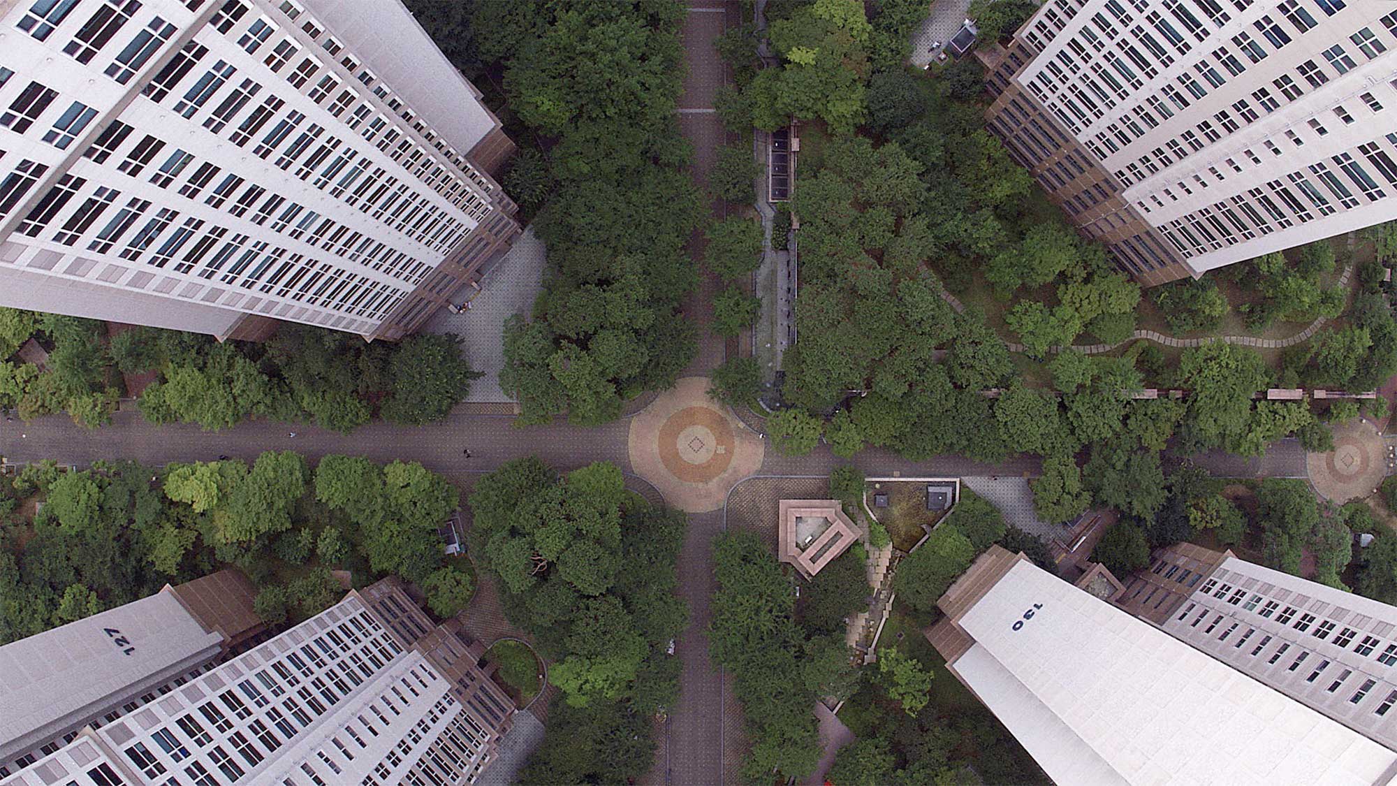 Drone shot from bird's-eye perspective looking down on apartment complex buildings surrounding a square in Seoul, South Korea.