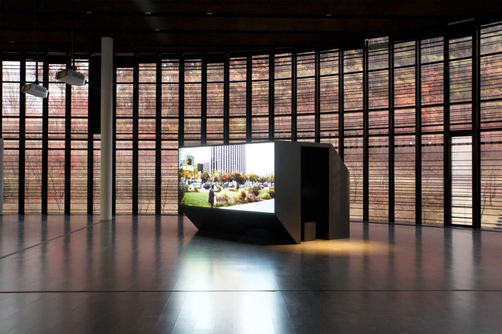 Large screen box in spacious atrium, framed by high glass facade during BLAST THEORY - YOU START IT exhibition, Nam June Paik Art Center, Seoul, South Korea.