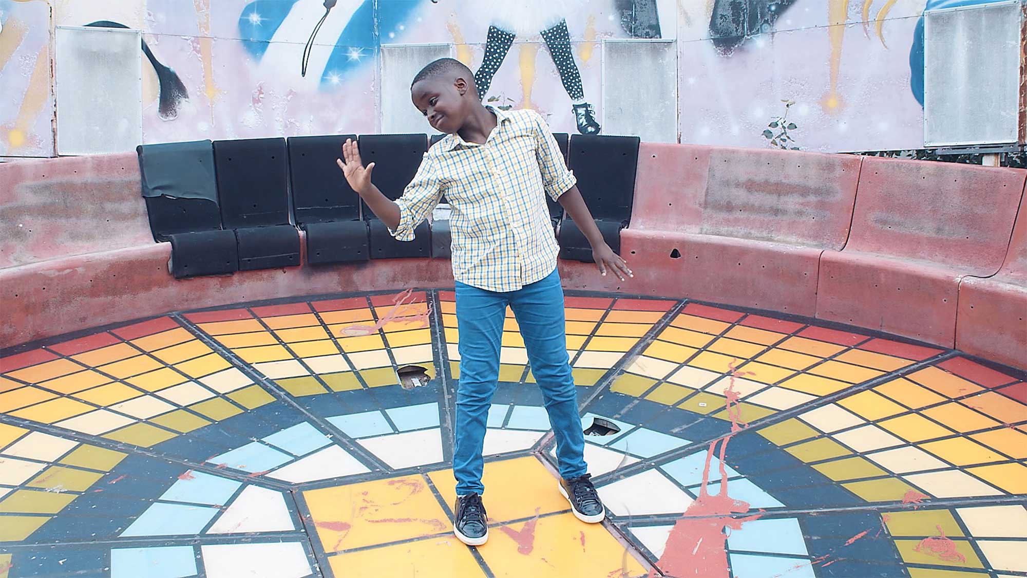 Young boy performs dance on an old fun-fair ride at abandoned fun-fair park in Seoul, South Korea.