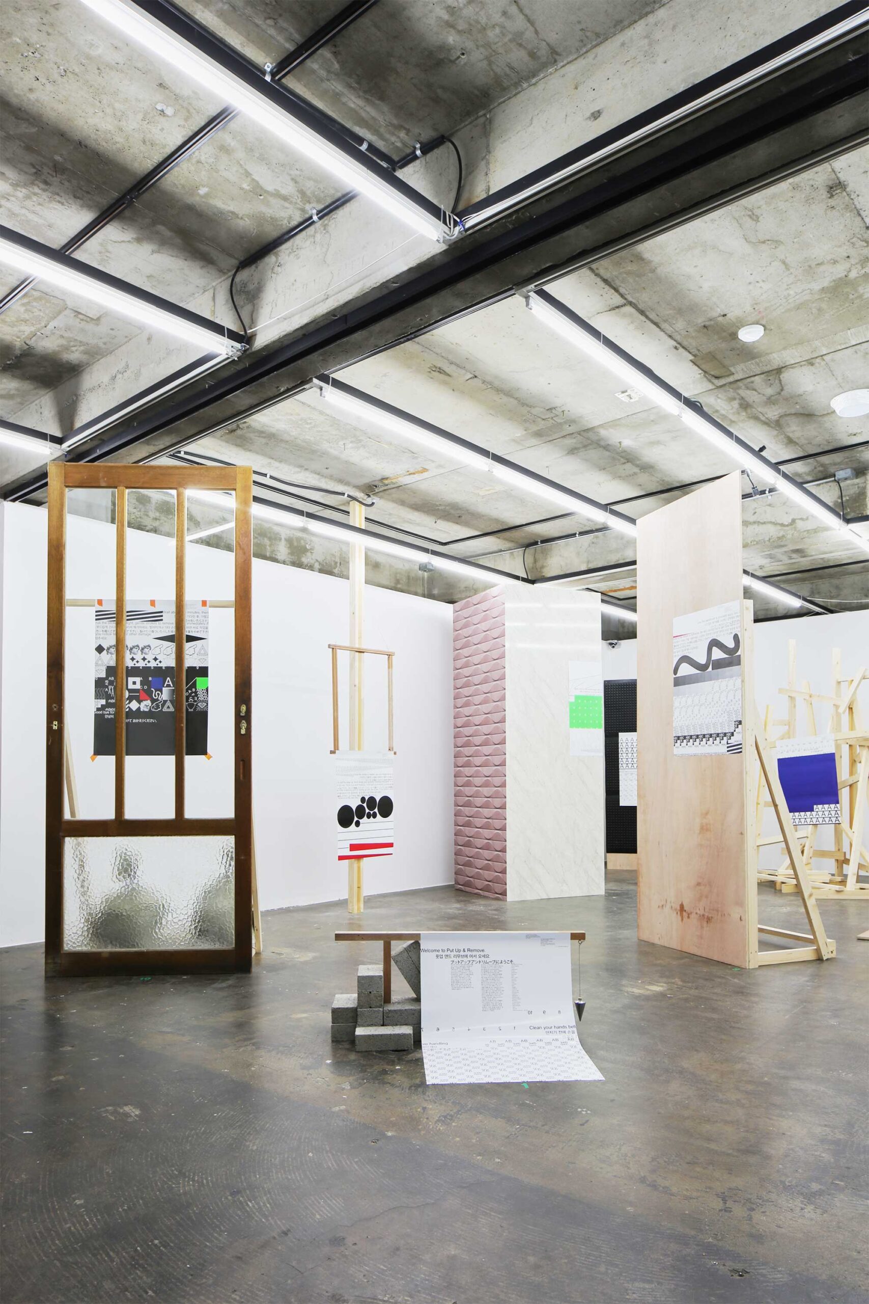 Different types of posters hung in unusual ways as part of the installations for the poster exhibition in Seoul, South Korea, by Graphic Magazine as part of Propaganda Press.