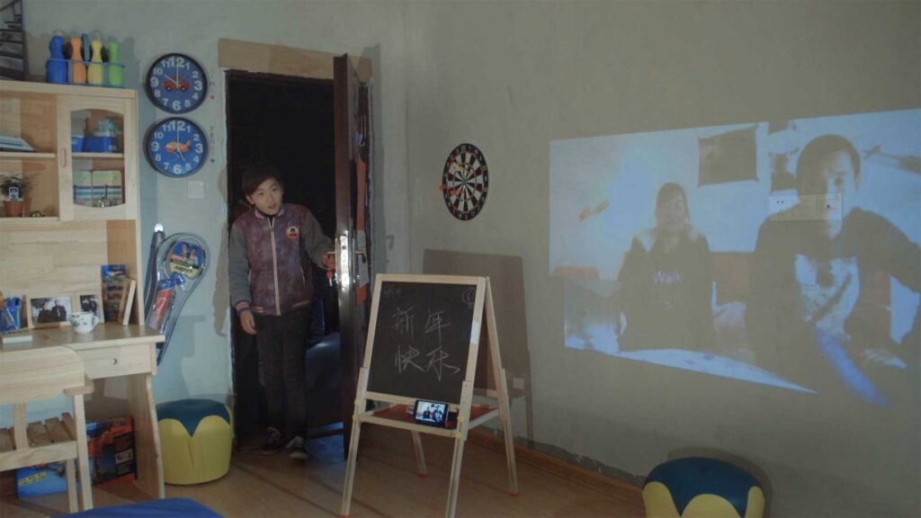 As part of a Western Union Chain of Betters campaign, a young Chinese boy enters his newly decorated children's room in Changle District, China, while his parents, residing in Italy, are projected onto the wall via a video call.