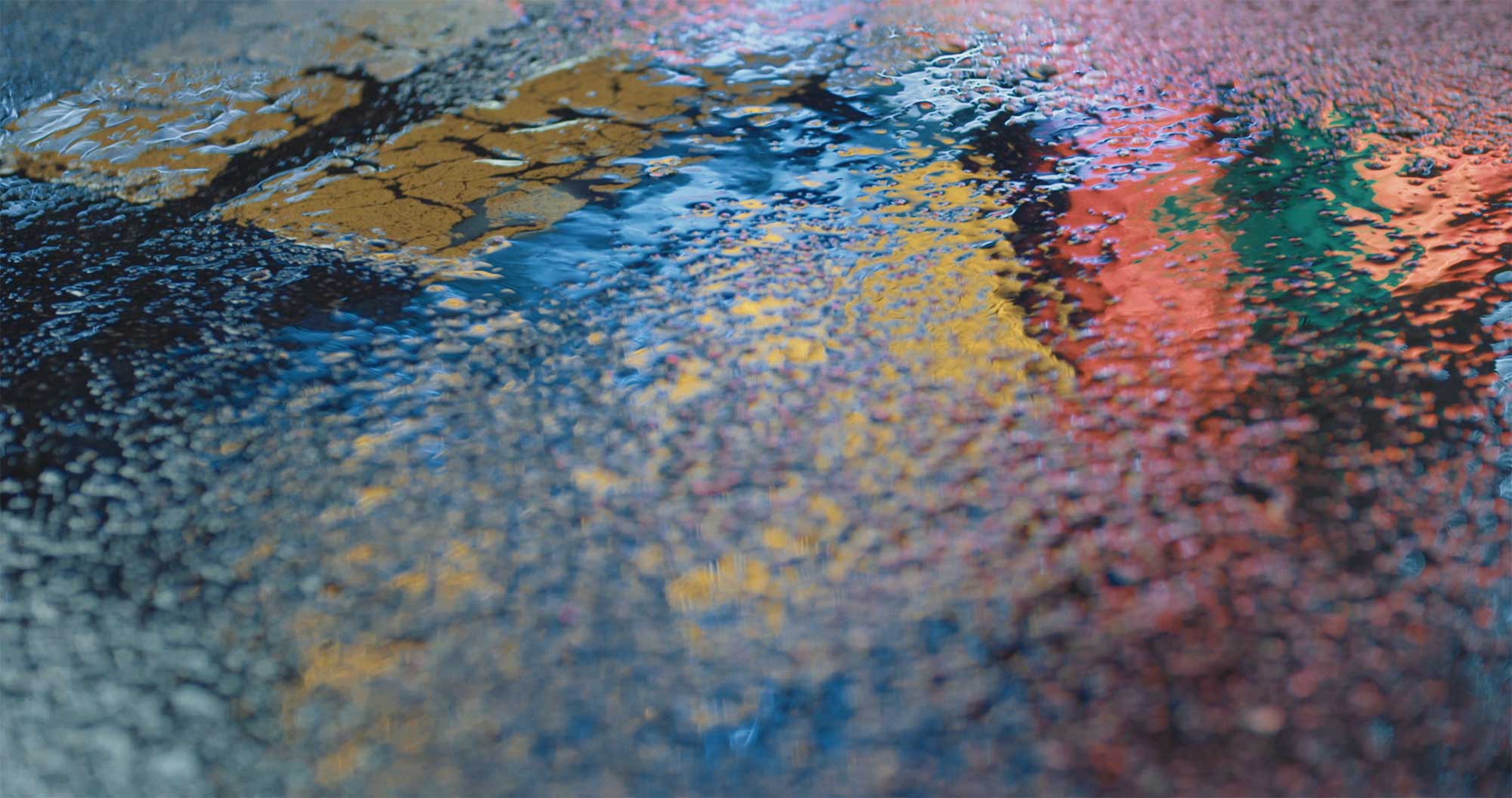 Neon light reflecting in multiple colors on wet rainy street in Seoul for short film Seoul City Machine