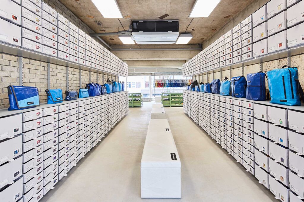 White shelves line both sides of Freitag store on Jejudo, showcasing newest bags at D&Department Jeju by Arario.