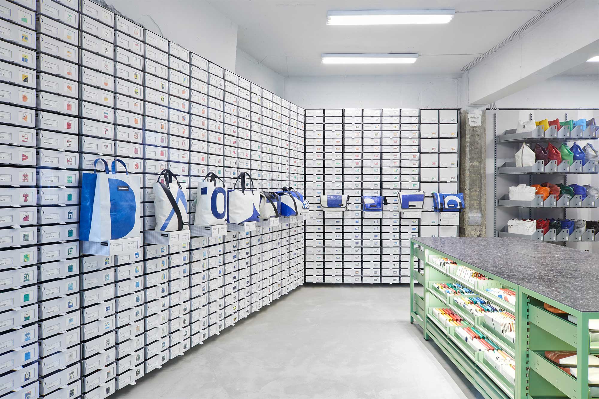 Interior view of Freitag Seoul Apgujeong store showing tall white shelf curving from floor to ceiling.