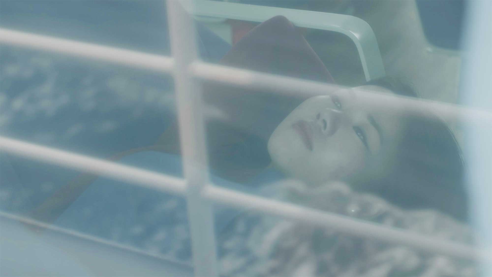 Portrait of north korean female refugee lying on ferry seats to kapado boat railing and passing water reflected on window near Jeju Island South Korea