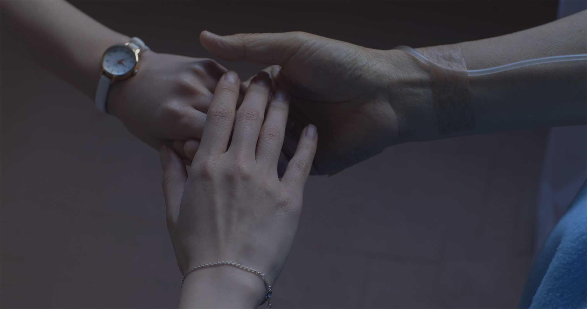 Two women’s hands supporting elderly hand in Samsung Life Insurance video