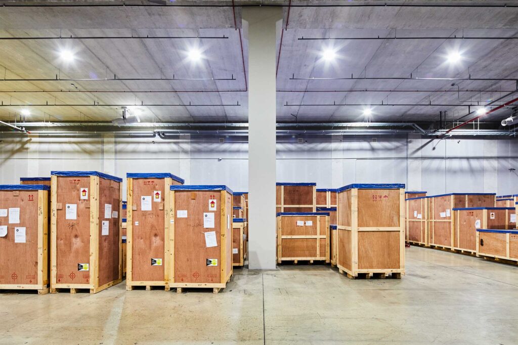 Wooden shipping crates lined up in warehouse interior.