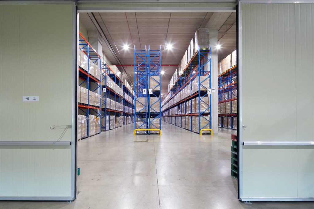 Open door showing goods-lined warehouse corridor.