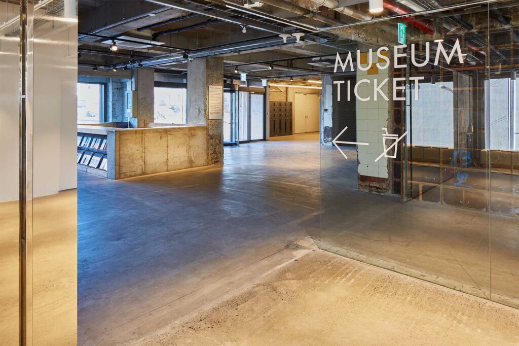 Intersection of commercial area and Arario Museum in D&Department Jeju by Arario, combining raw concrete and glass.