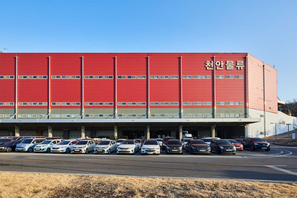 Logistics center facade with parked trucks outside Seoul.