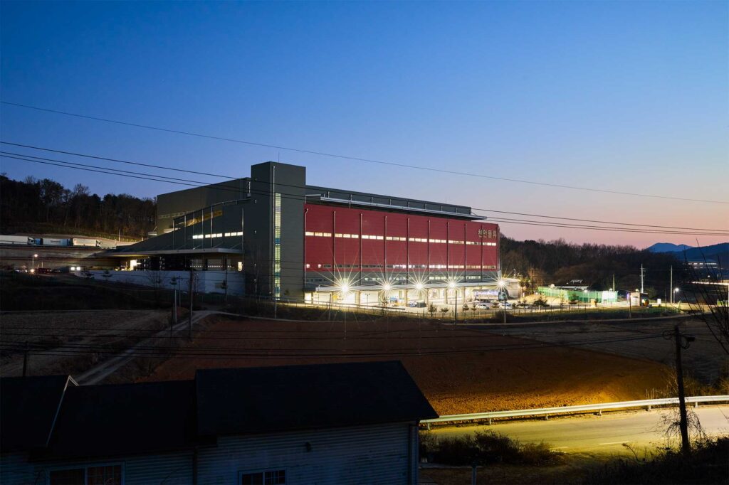 Logistics center illuminated at dusk outside Seoul.