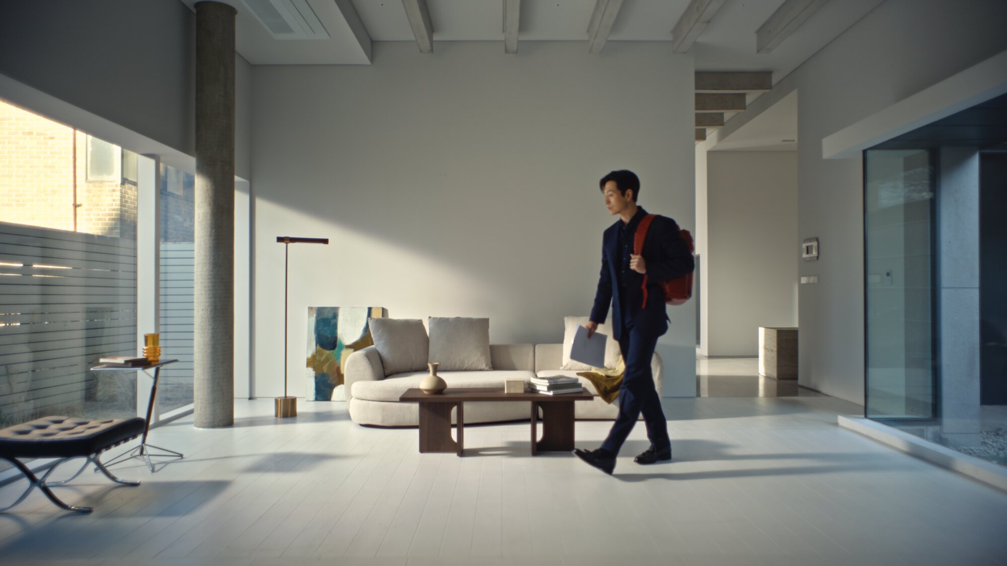 Jung Sung Il walking with Piquadro backpack in modern Seoul interior