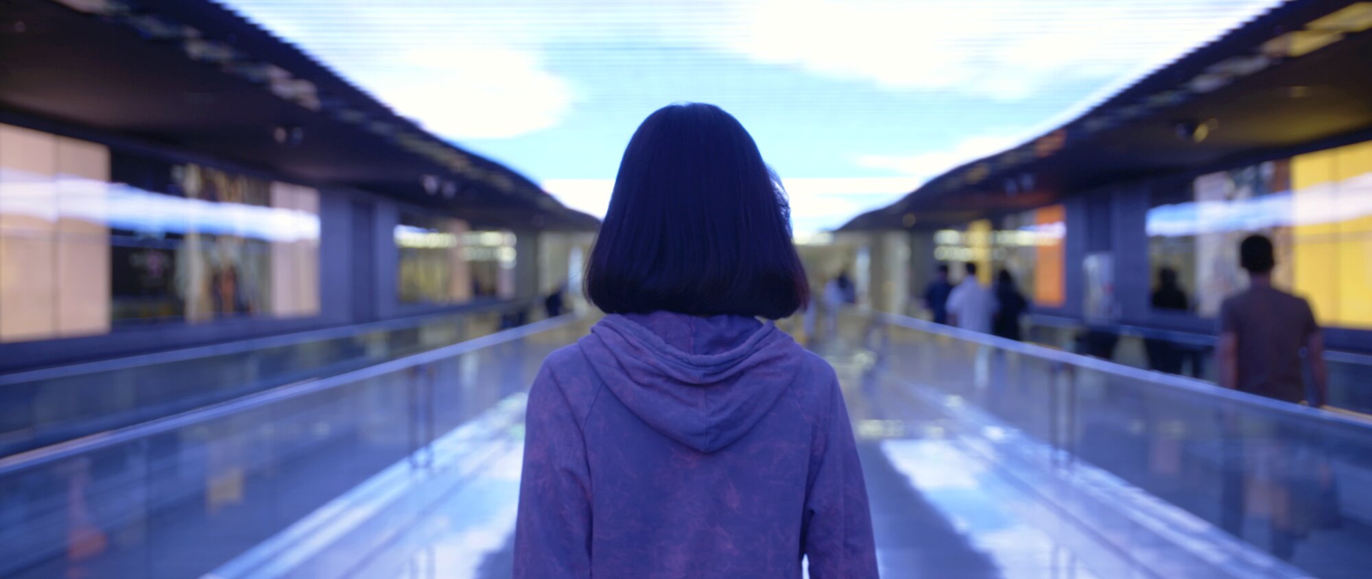 Hye Sun walking through illuminated airport corridor for Hana Korea