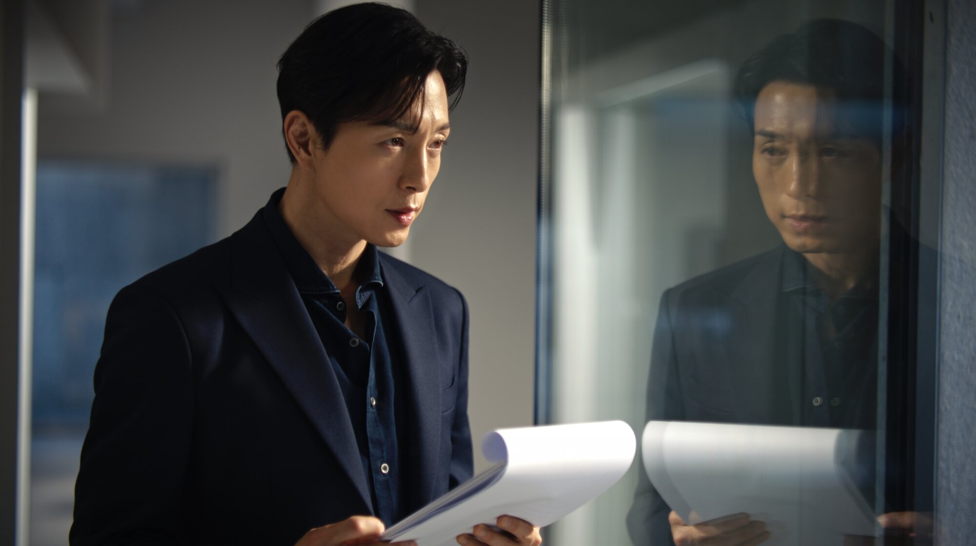 Jung Sung Il reading document wearing Piquadro in modern Seoul office