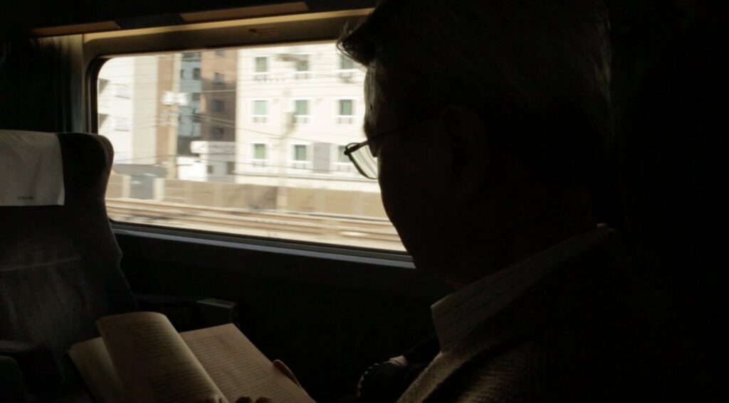 Korean professor reading on KTX train en route to KAIST Daejeon for documentary ZDF Wirtschaftswunder Korea
