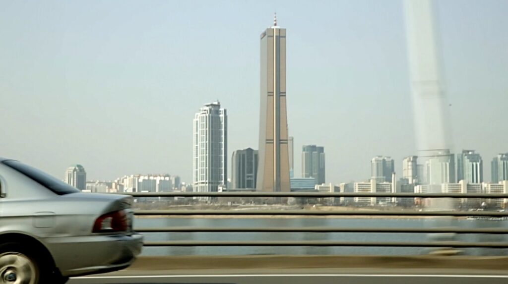 Car crossing bridge with view of Yeouido skyline and 63 Building in Seoul for documentary ZDF Wirtschaftswunder Korea
