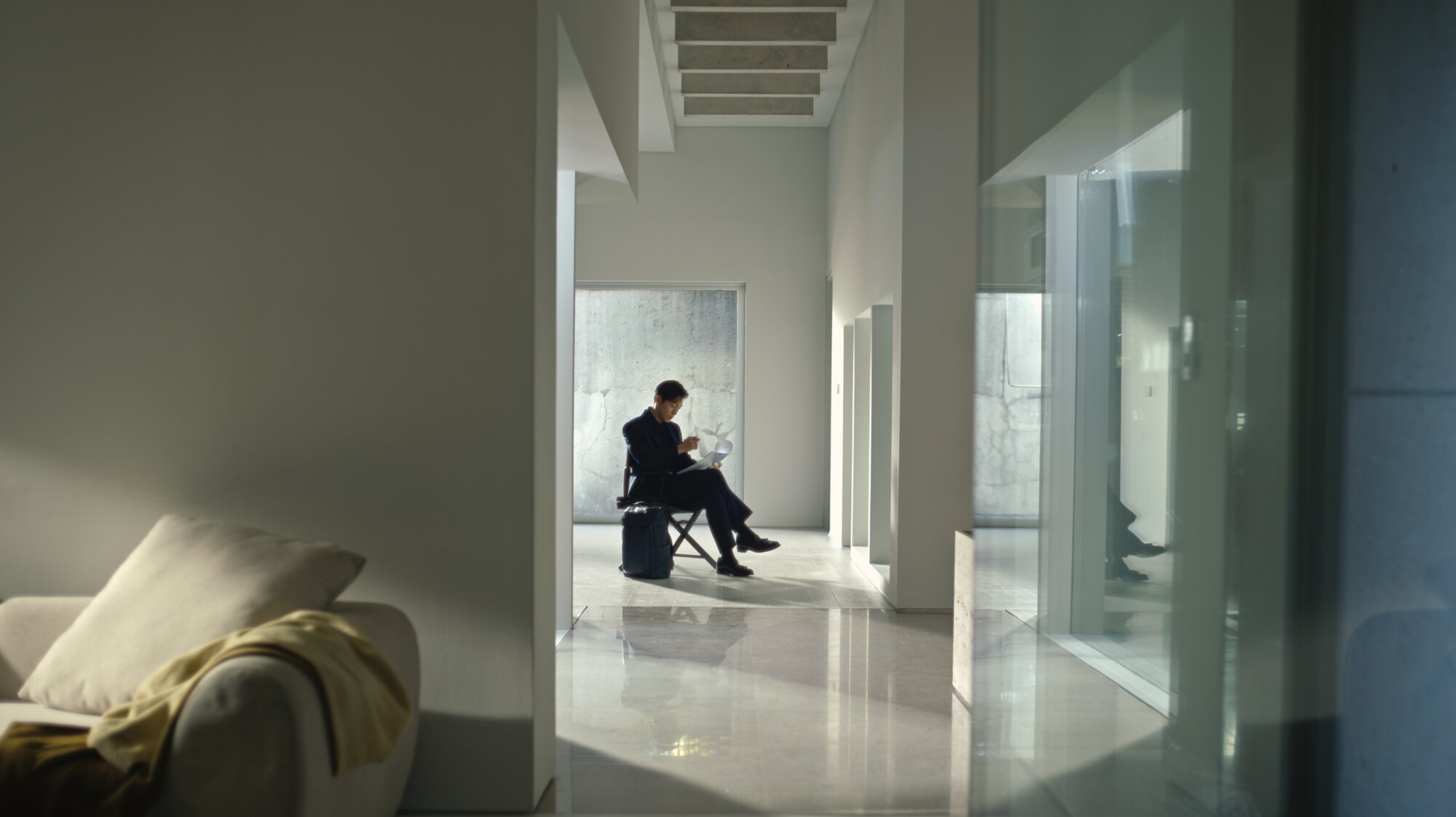 Jung Sung Il seated reading with Piquadro bag in modern Seoul space