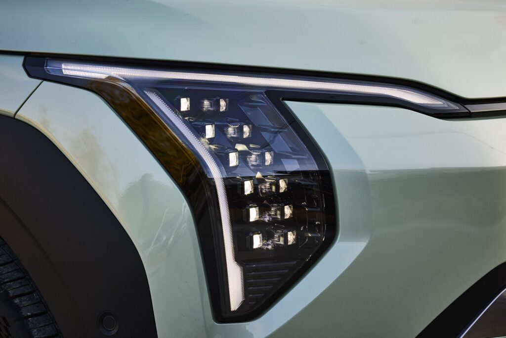 Kia EV3 front light with LED signature beside hanok architecture.