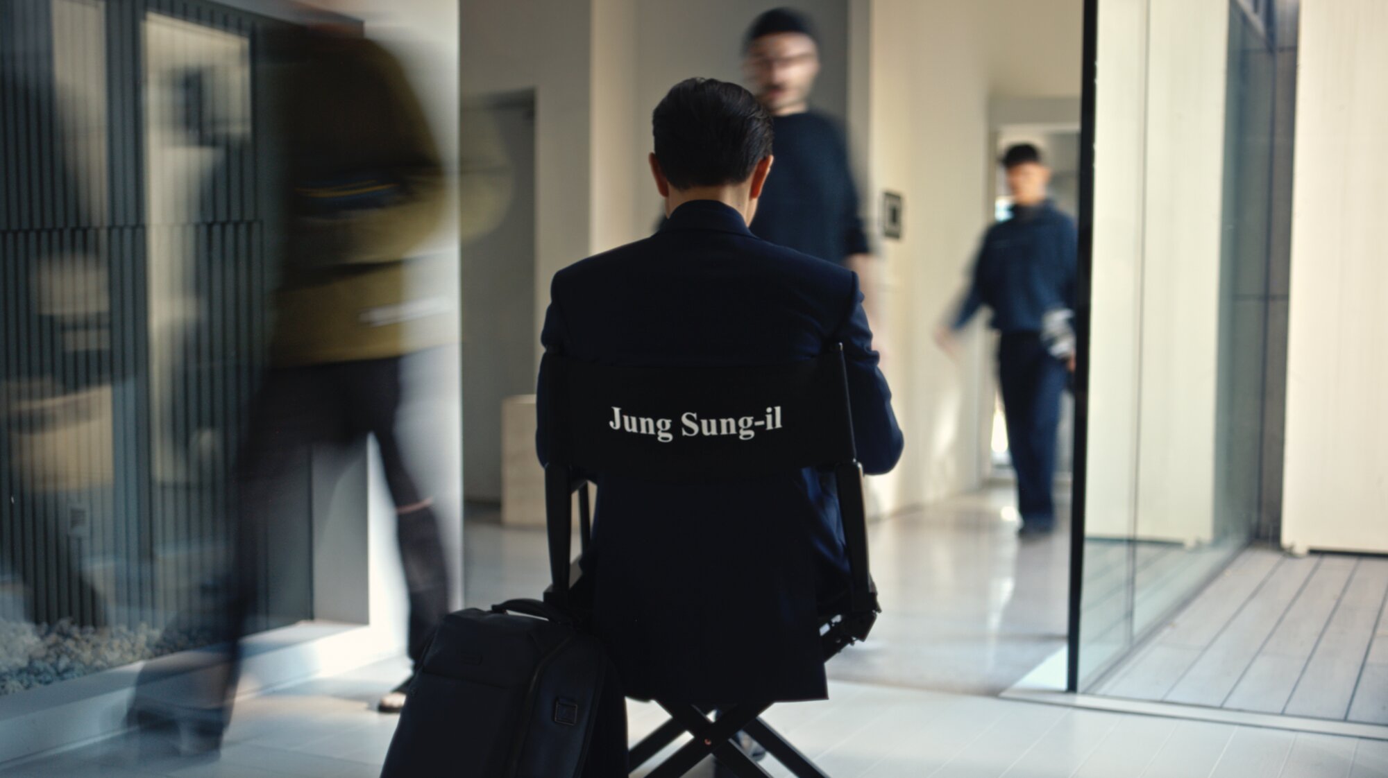 Jung Sung Il seated with Piquadro trolley on director chair Seoul
