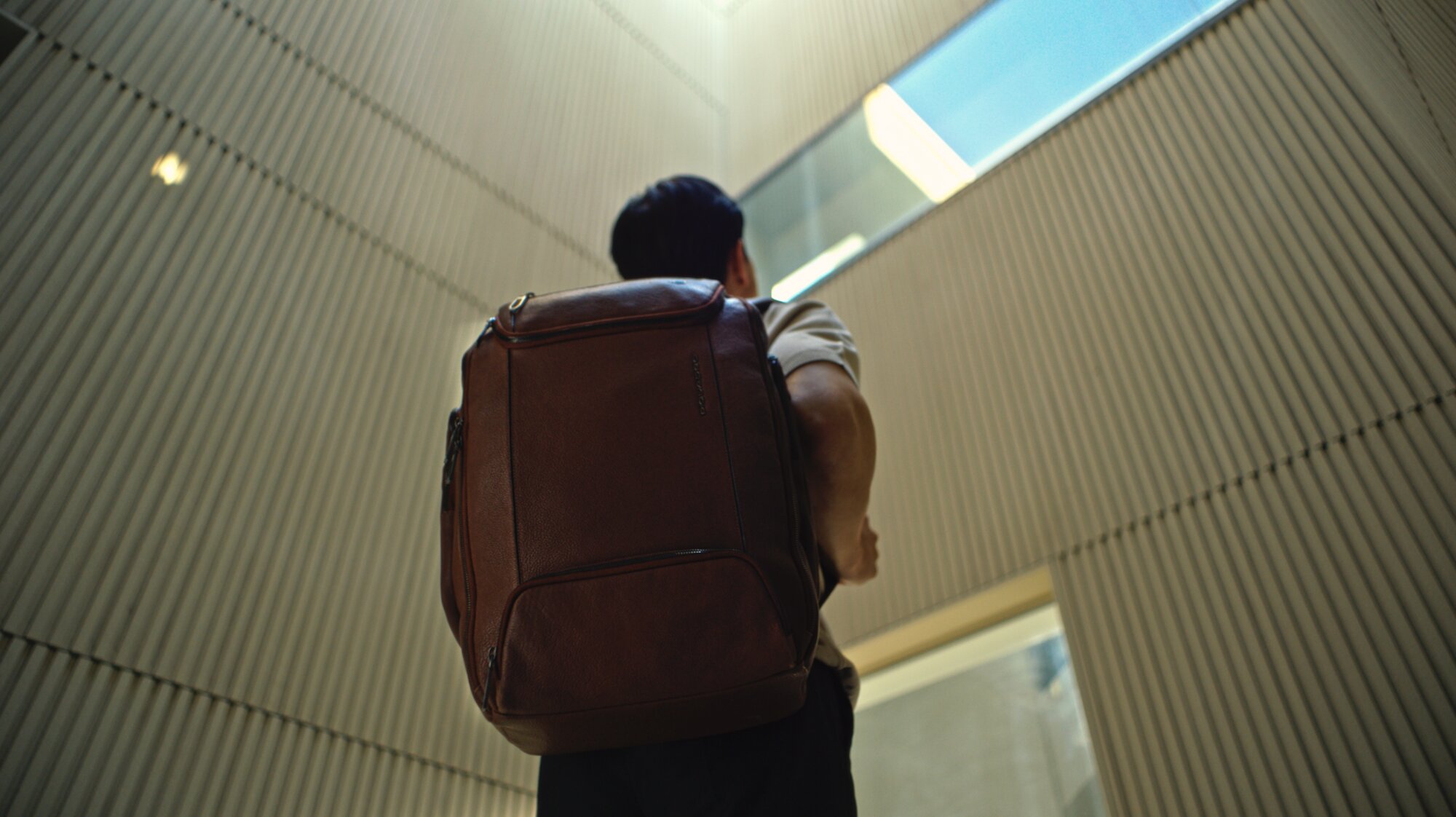Jung Sung Il climbing courtyard steps wearing Piquadro backpack Seoul