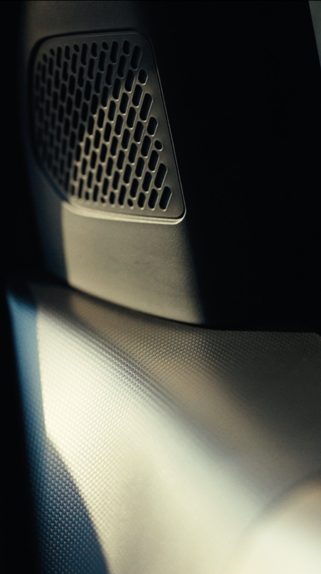 Close-up of Kia EV3 interior speaker catching soft light.