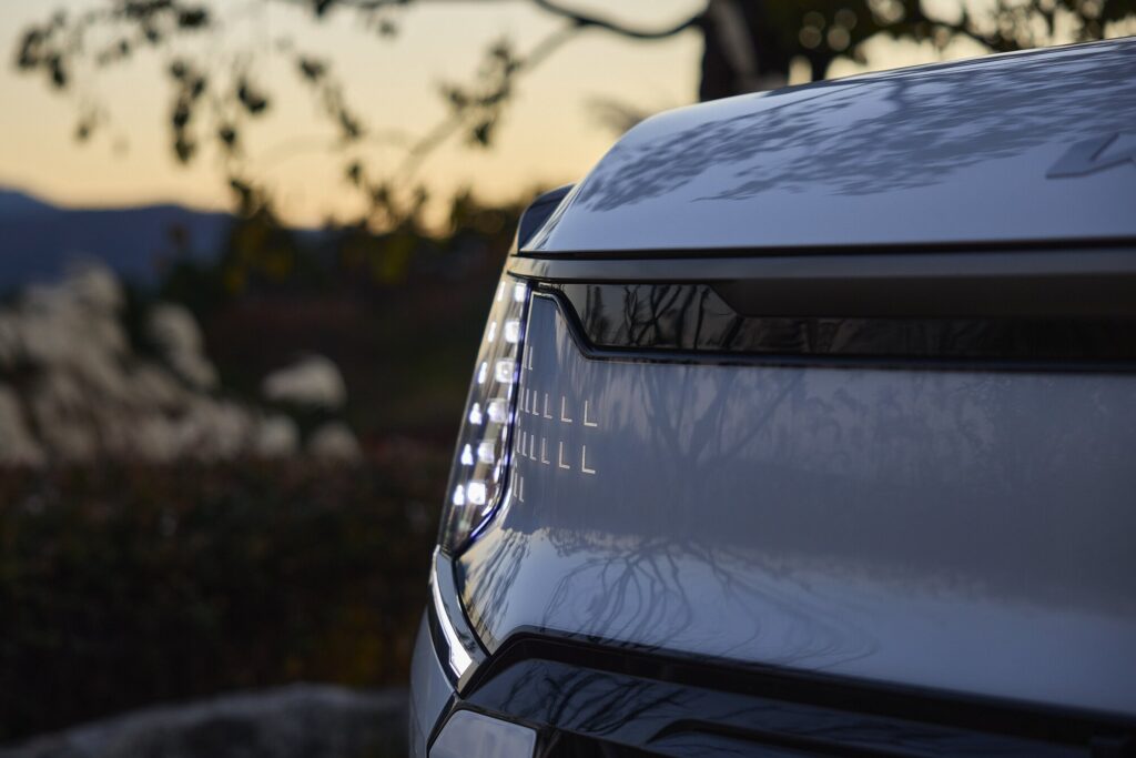 EV9 front light signature at dusk set against Sayuwon landscape.