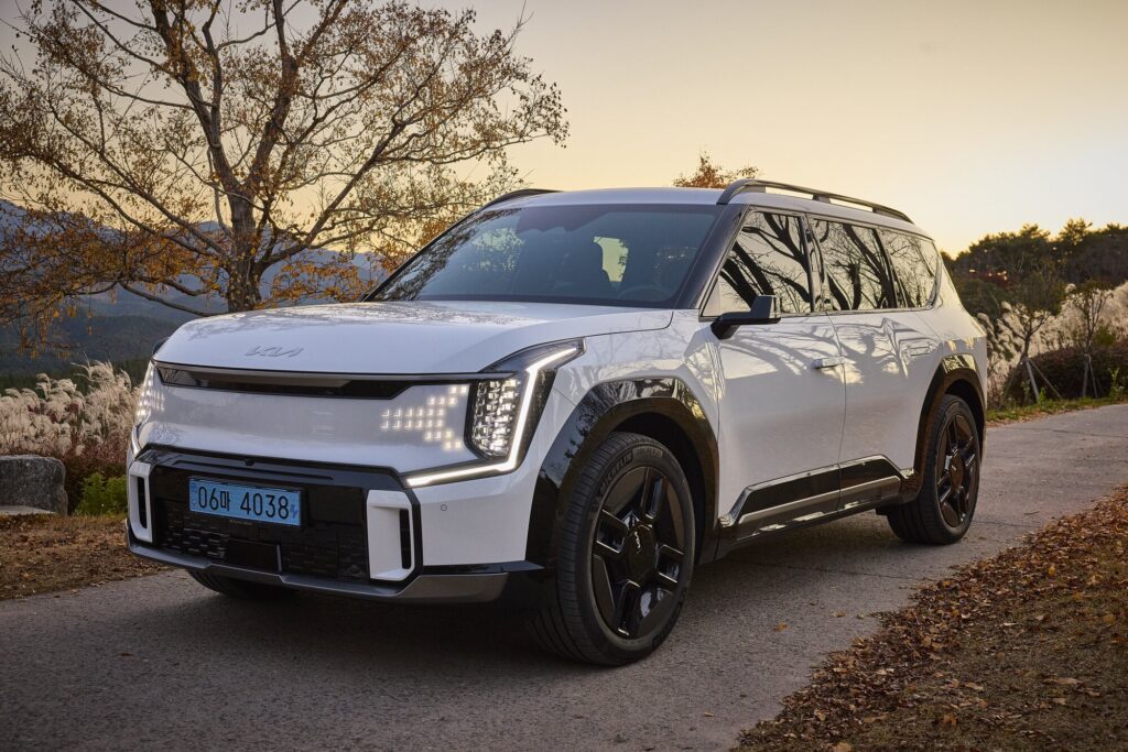 EV9 illuminated front at dusk within Sayuwon landscape.