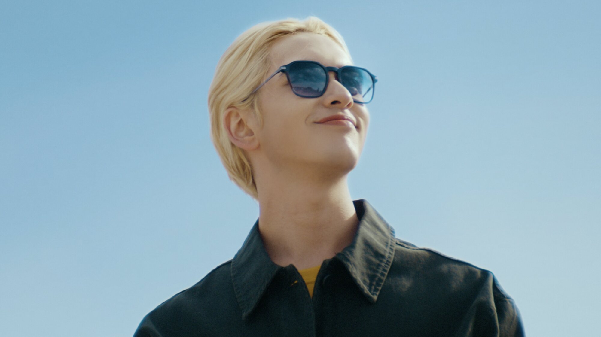 Blonde model wearing sunglasses against blue sky Seoul