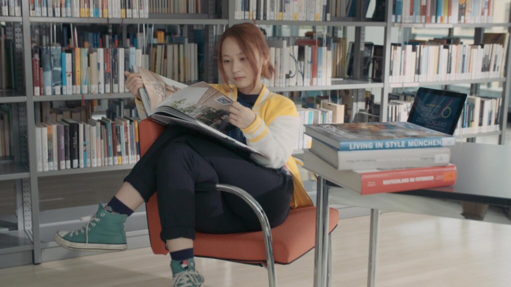 Korean actress Kkobbi Kim reading book inside library space at Goethe Institut Seoul during cultural promo film project focused on language education and exchange