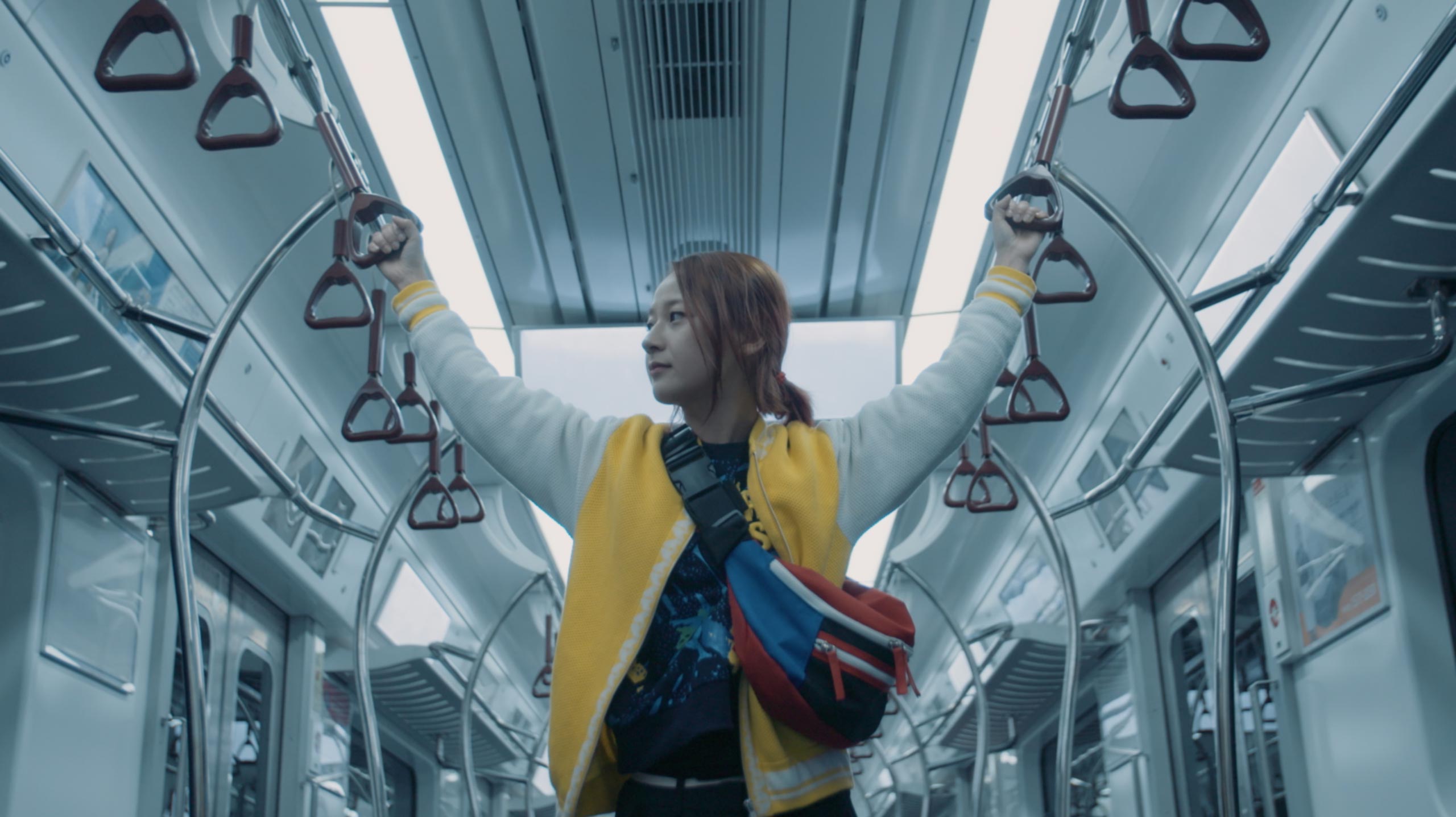 Korean actress Kkobbi Kim standing inside Seoul subway train during Goethe Institut Seoul promo film reflecting everyday movement urban life and cultural exchange