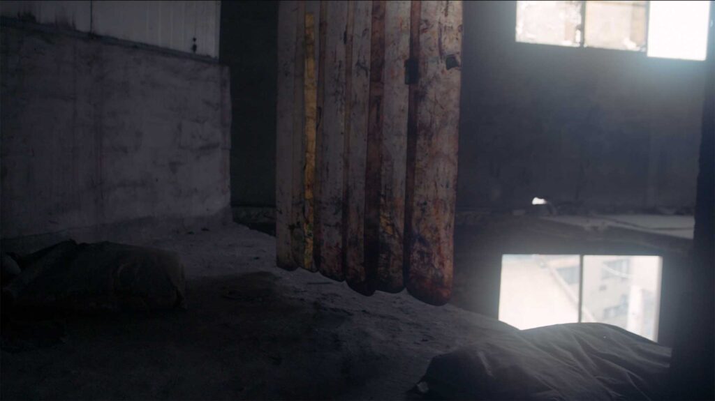 Empty factory interior with worn curtains and light entering through windows reflecting absence memory and industrial labor conditions in South Korea