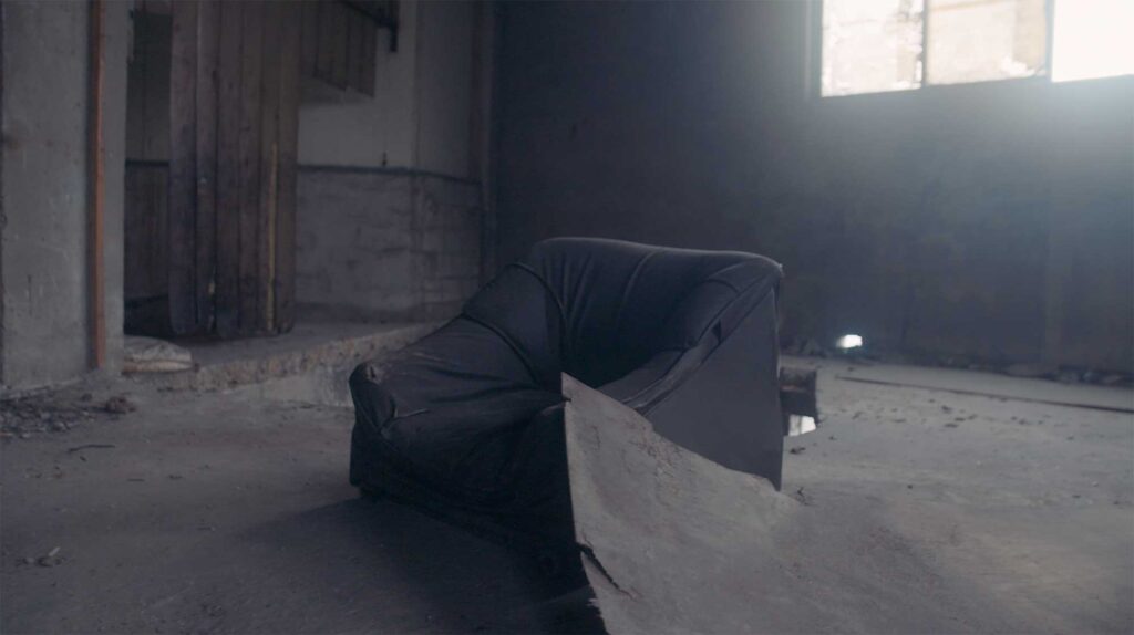 Discarded armchair inside abandoned factory space symbolizing exhaustion neglect and everyday life of industrial workers in South Korea