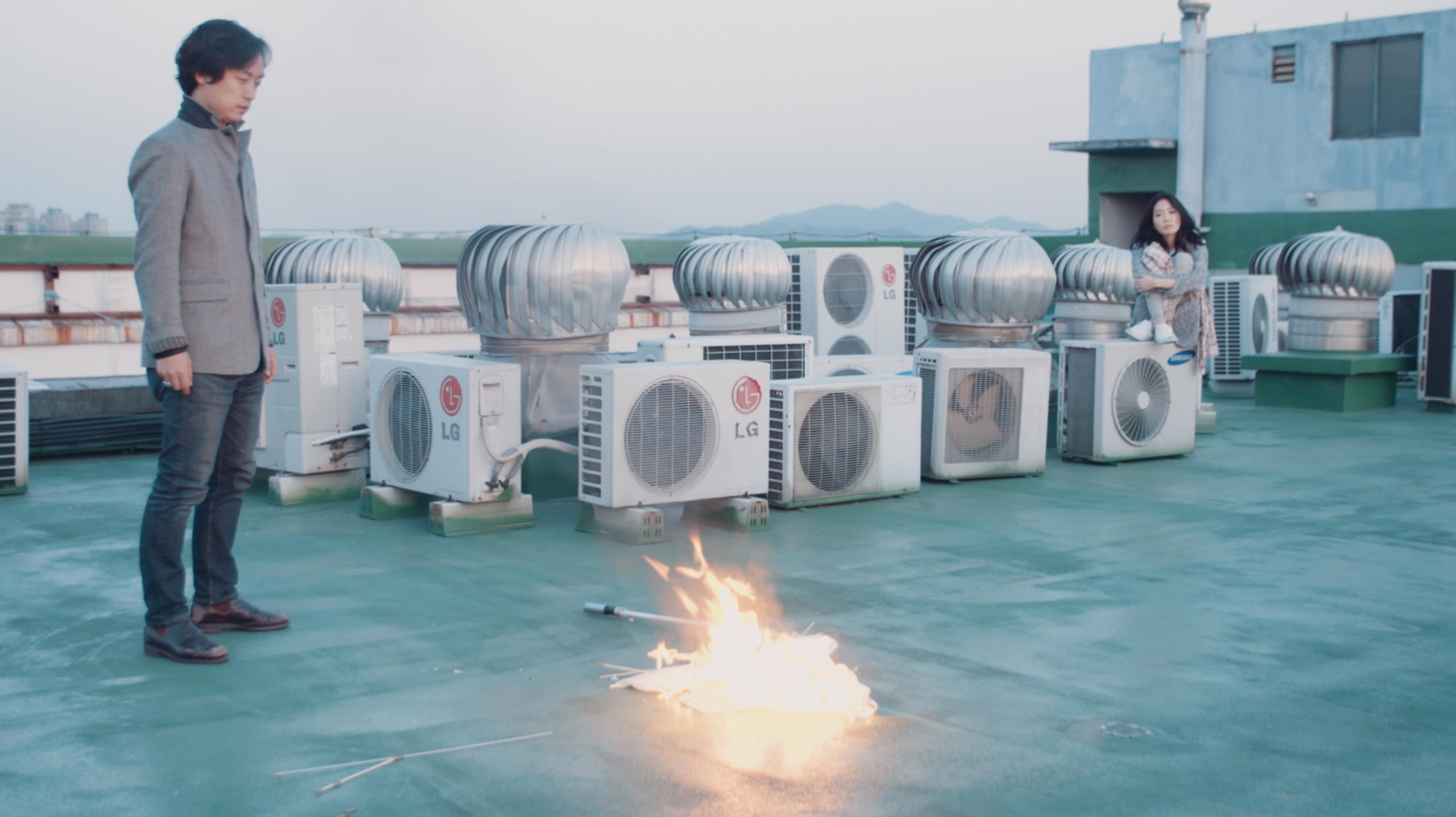 Performance moment on rooftop in Seoul with burning umbrella during Goethe Institut Seoul promo film exploring gesture ritual and urban atmosphere