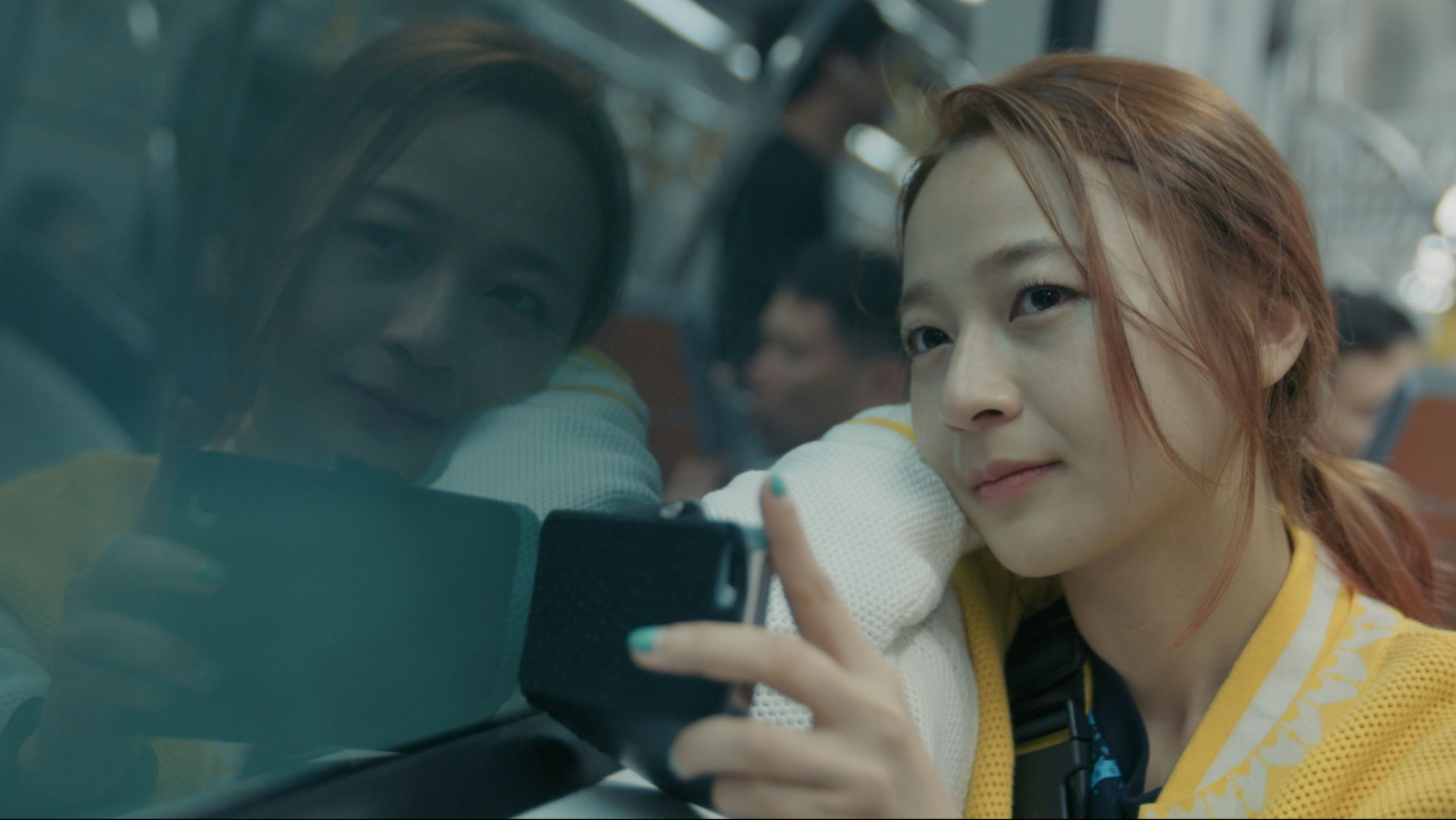 Korean actress Kkobbi Kim looking through subway window in Seoul during Goethe Institut Seoul promo film capturing reflection movement and everyday urban travel