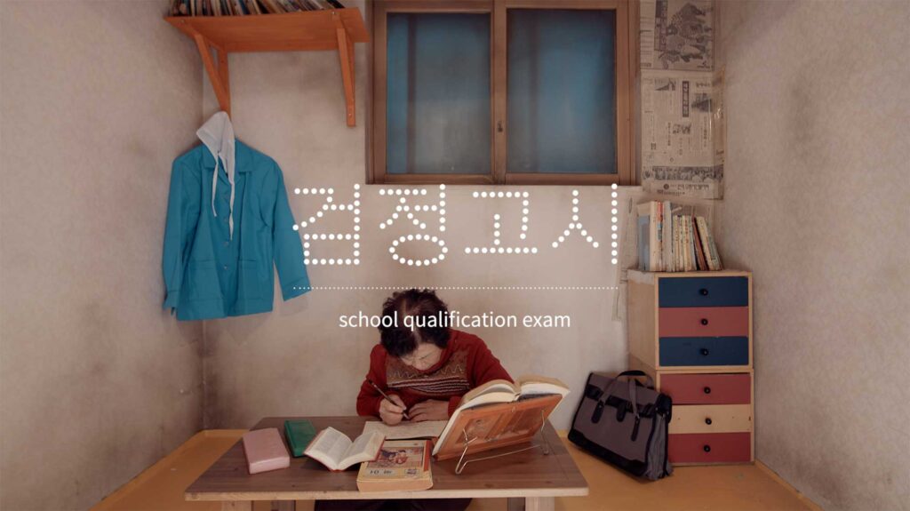 Former factory worker studying for a school qualification exam reflecting delayed education and self-improvement shaped by industrial labor