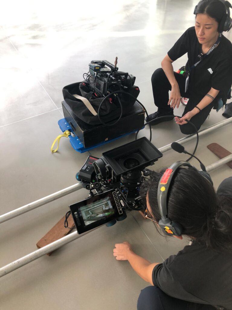 Camera and sound crew preparing a low-angle tracking shot on set in Seoul, focusing on precision, coordination, and equipment setup