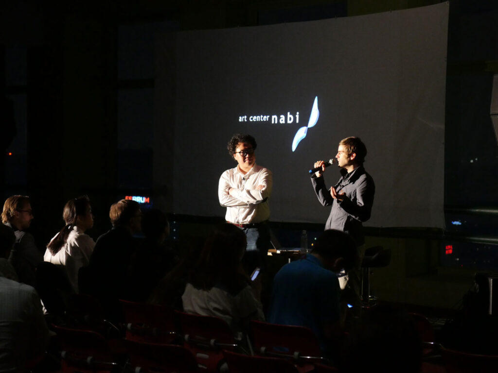Conversation at Art Center Nabi during the 7th Encounter, with curator Jaewon Choi and filmmaker and photographer Nils Clauss discussing urban space and observation in Seoul.