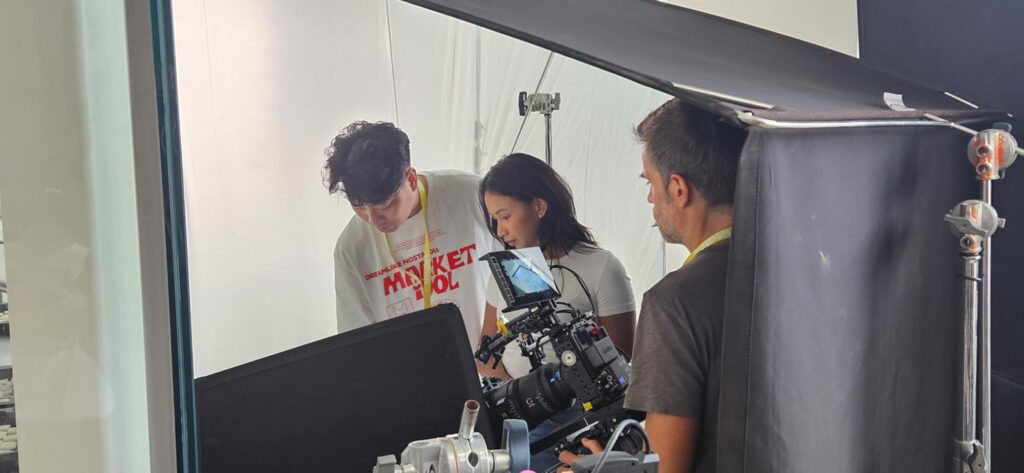 Director of photography and crew reviewing a camera setup under controlled studio lighting, aligning framing and exposure during a commercial shoot in Seoul