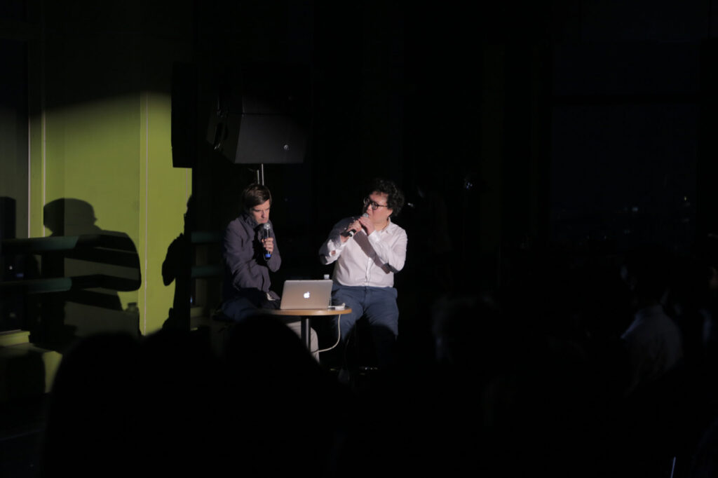 Jaewon Choi and Nils Clauss seated on stage at Art Center Nabi during 7th Encounter exchanging thoughts on city observation and urban experience in Seoul