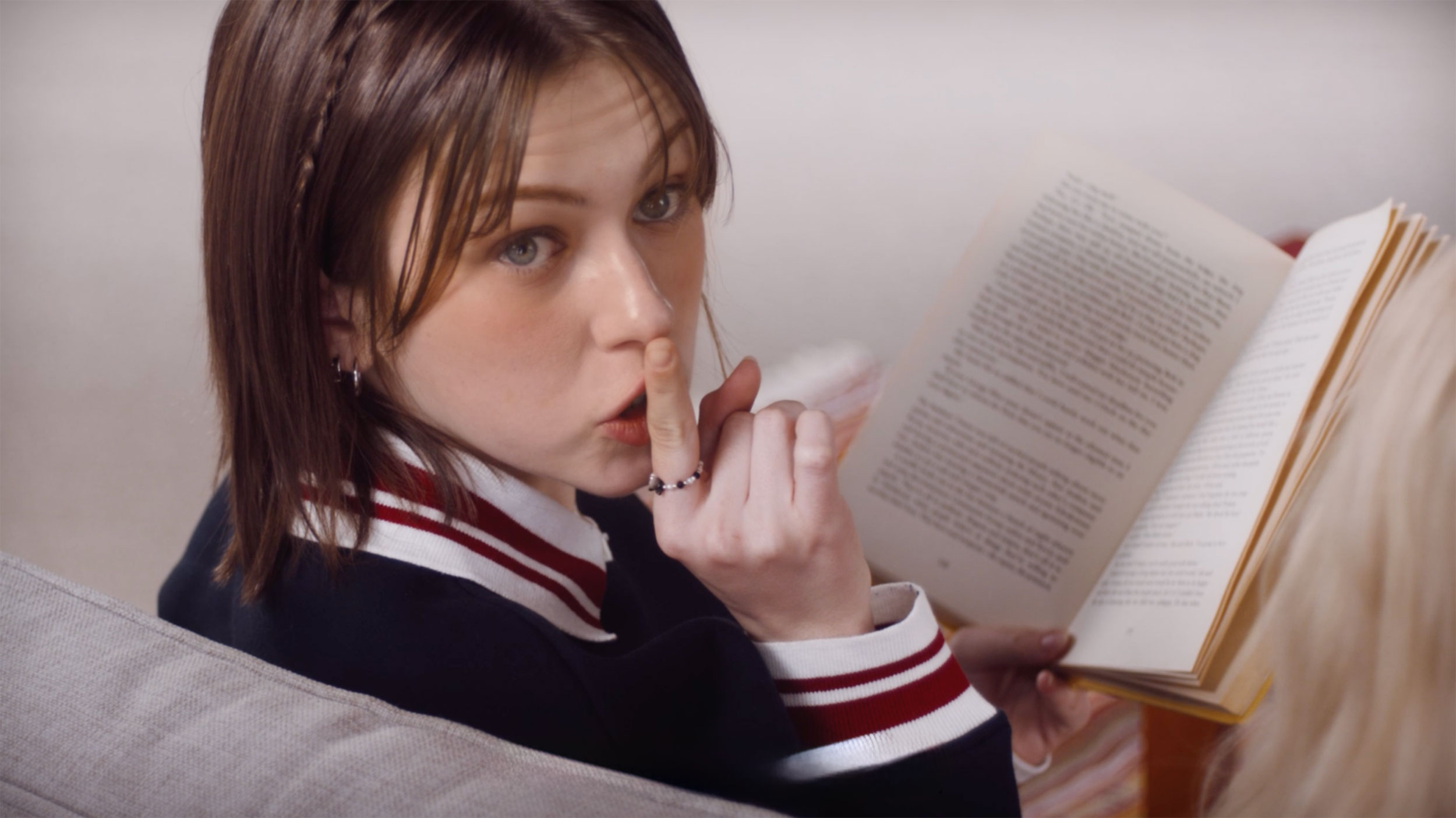 Freya Hawks reading a book in a studio living room for the Azar campaign