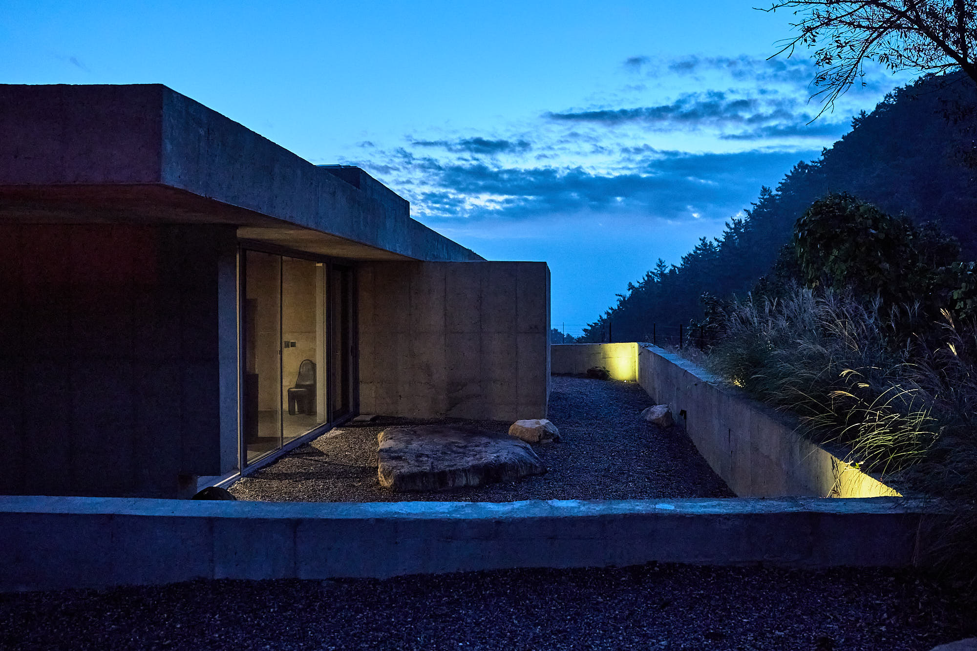Myök concrete architecture and landscaped courtyard at blue hour
