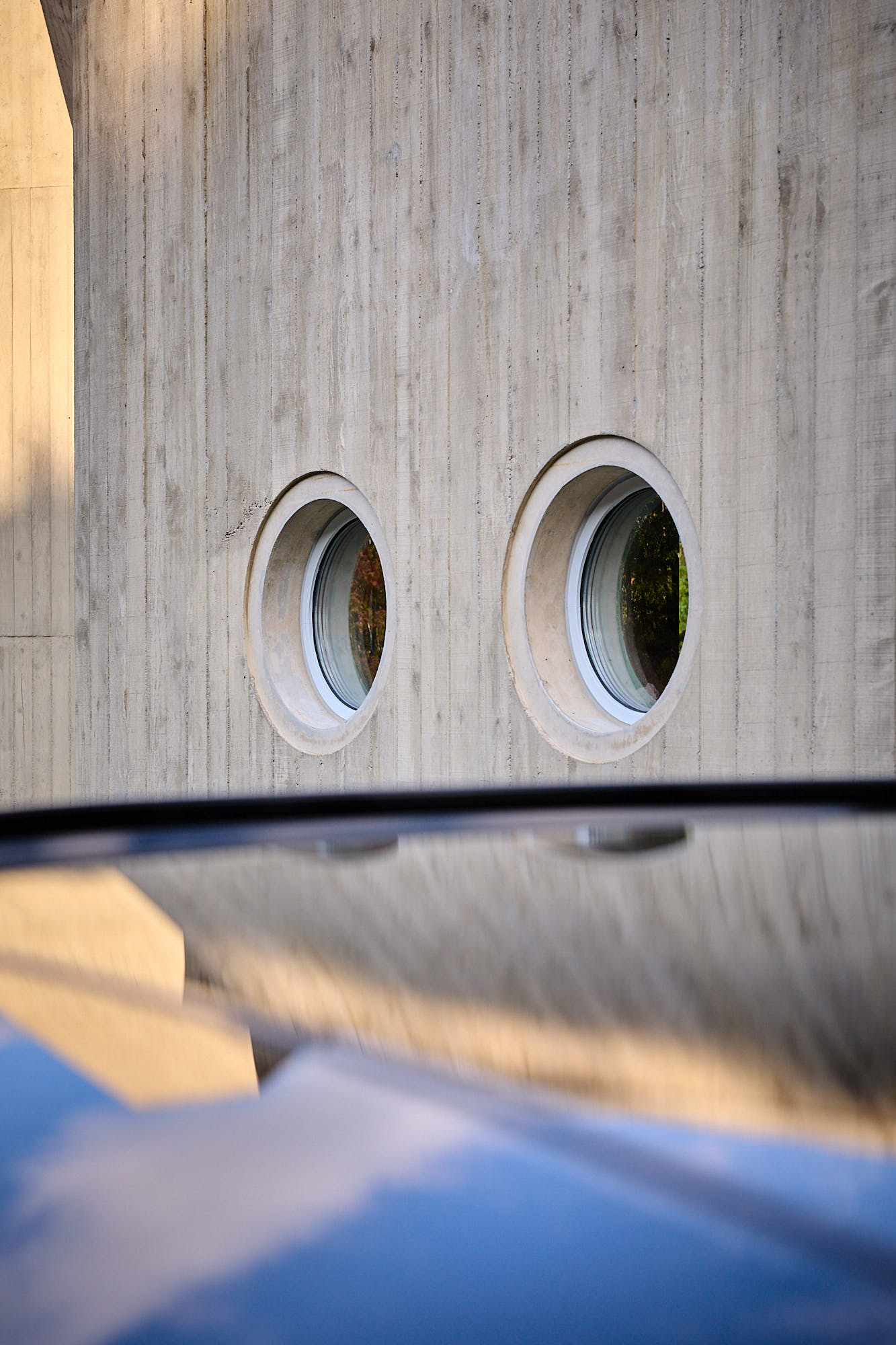 Circular Médongaule windows reflected on Kia EV5 bodywork