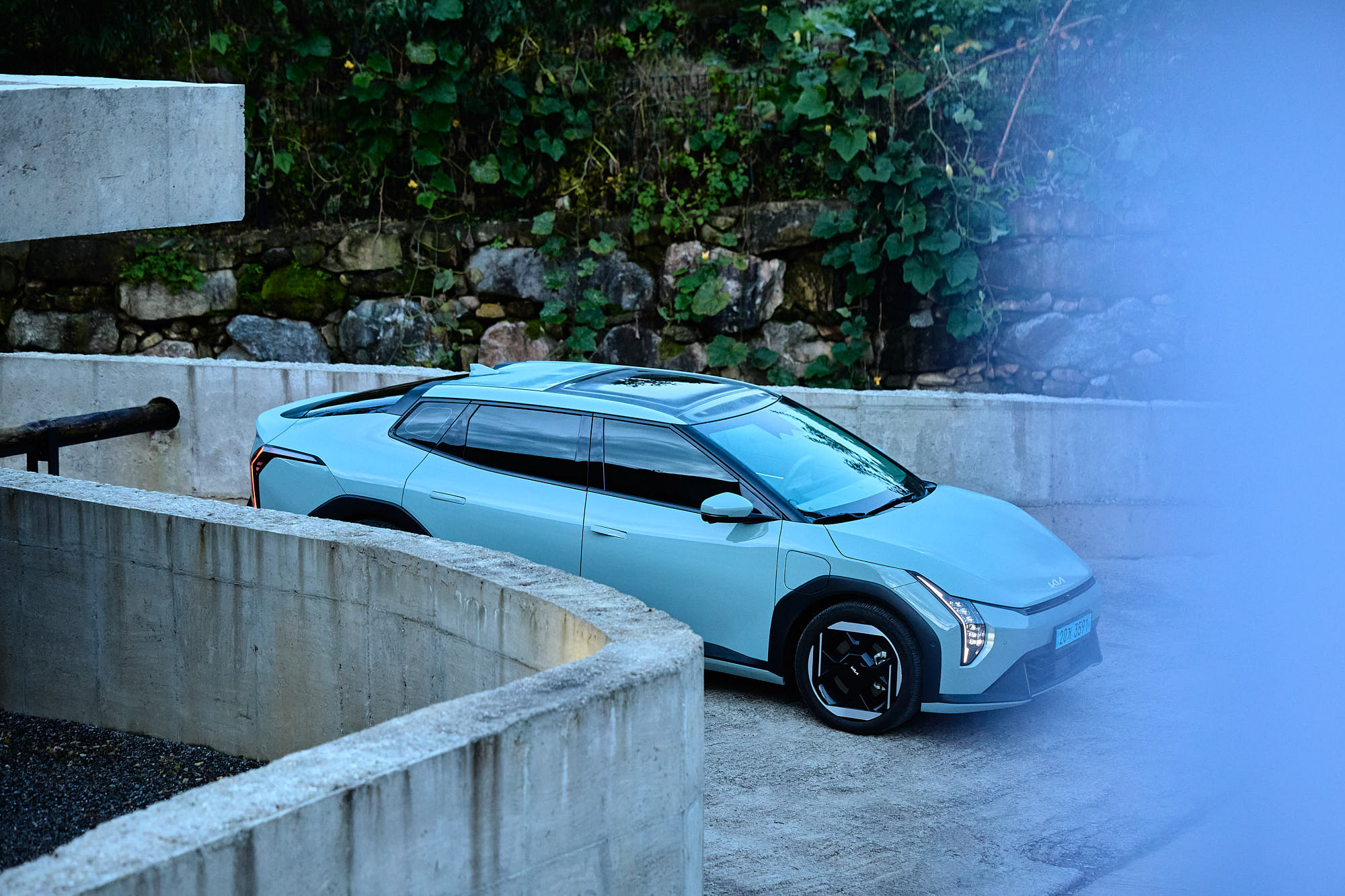 Kia EV4 framed by concrete walls and natural stone at Myök