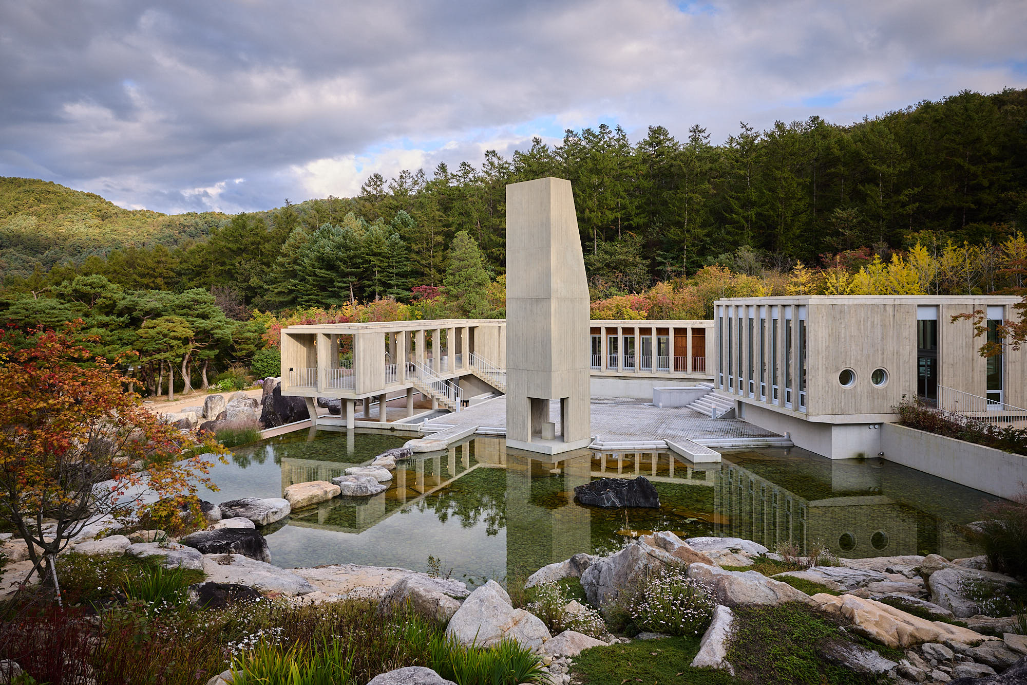 Médongaule concrete architecture and reflecting pond surrounded by autumn forest