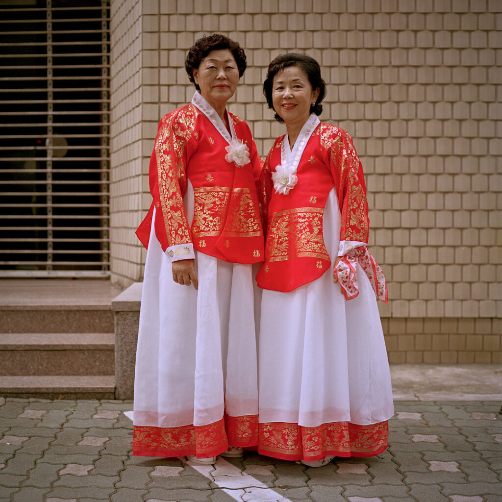 Elderly women in vibrant traditional Korean Hanbok dresses, adorned with ornamental golden print patterns