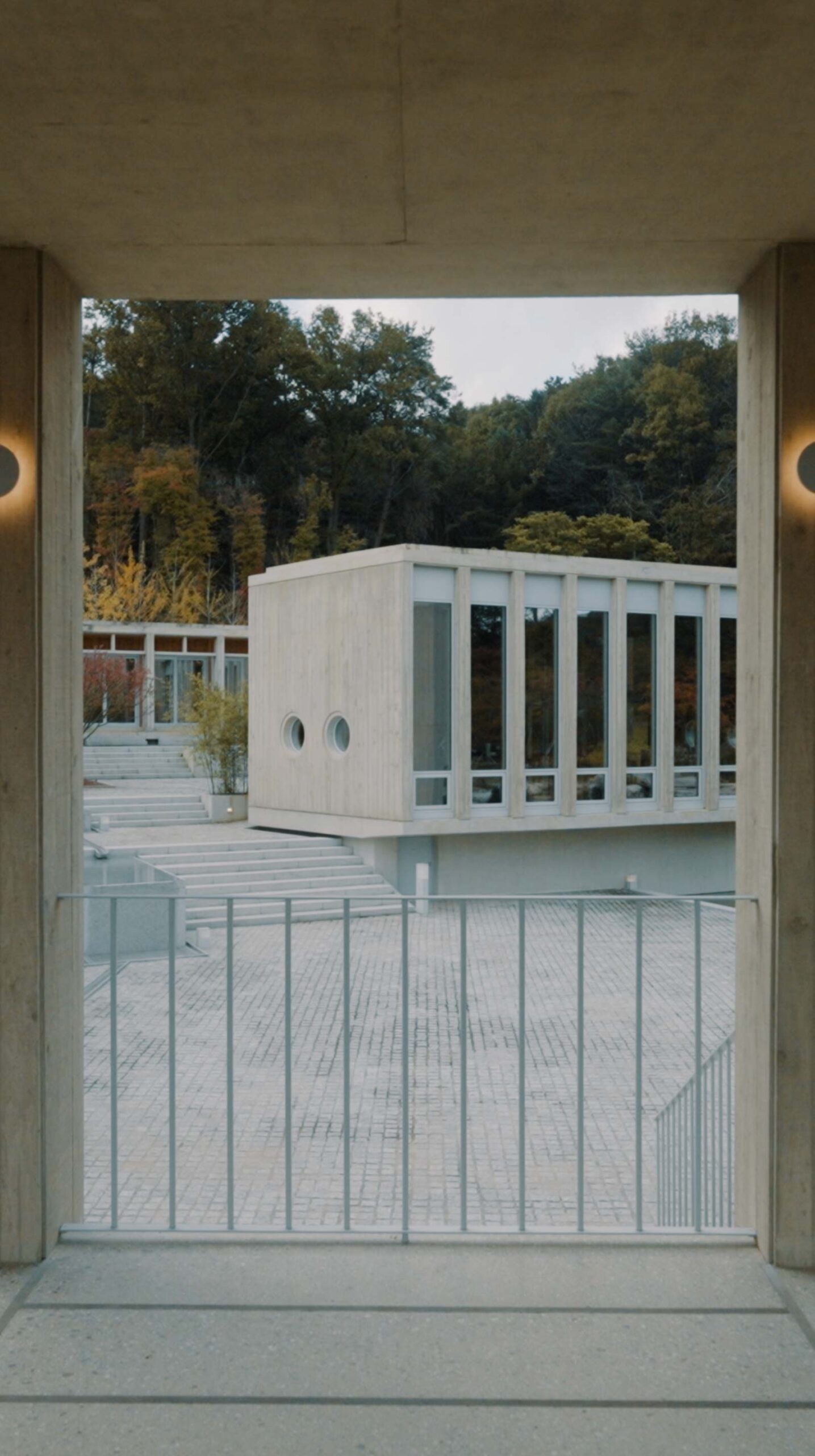 Médongaule concrete architecture framing a pavilion and autumn forest